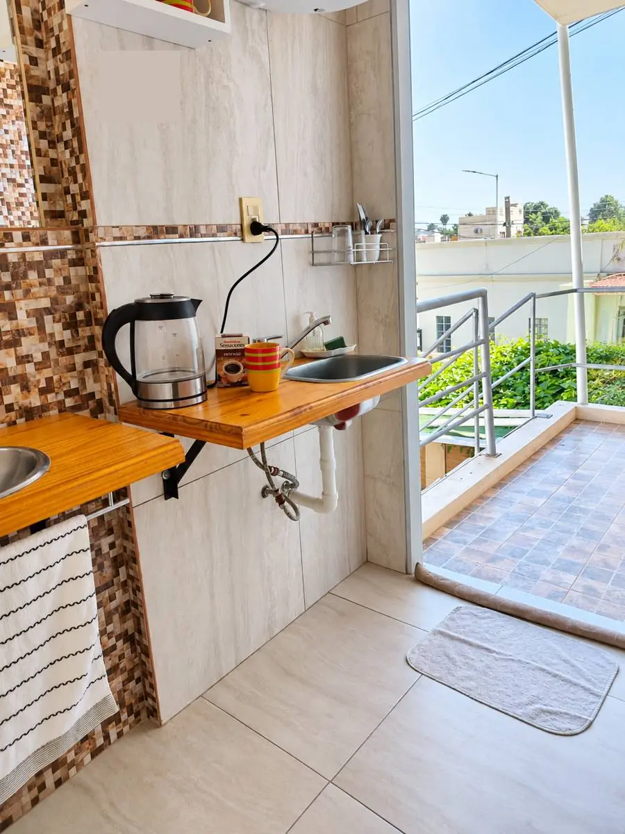 Mesada con pava eléctrica y puerta al balcón
