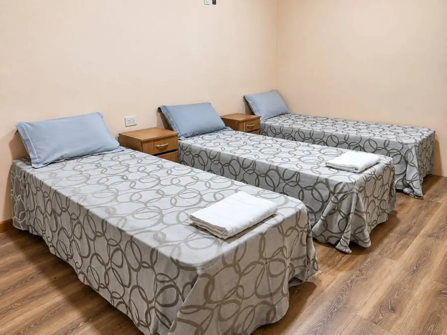 Extensión con tres camas individuales y mesitas de luz